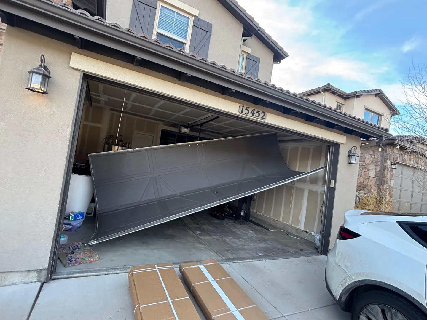 Damaged dark garage door before replacement