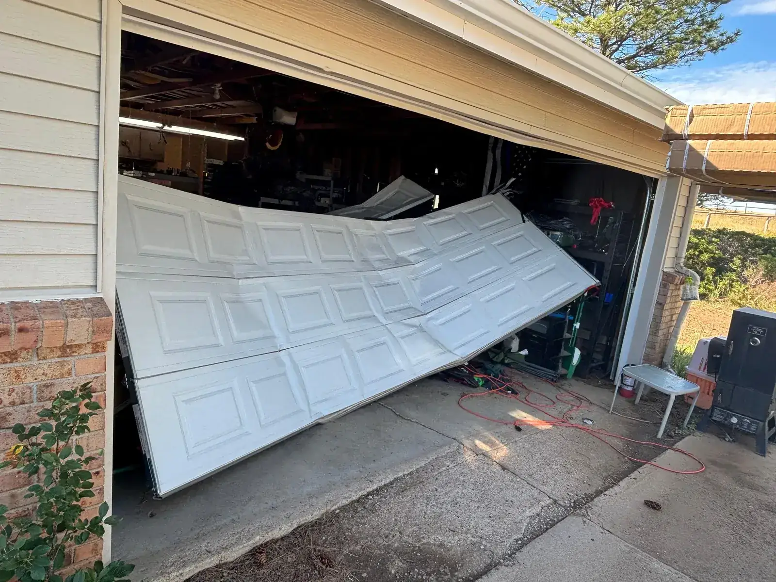 Collapsed white sectional garage door before replacement in the Denver area